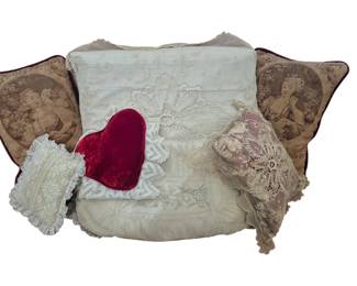 1263 - Vtg Decorative Pillow Collection 28"x27"x18" (Description): Collection of vintage decorative pillows  measuring 28"x27"x18". The assortment  includes a pair of tapestry pillows featuring  romantic figural scenes with burgundy  borders, a large pale blue embroidered pillow with floral motifs, a red velvet heart  shaped pillow, and delicate lace-trimmed  accent pieces in cream and mauve tones. A  charming grouping suitable for period or  romantic decor.