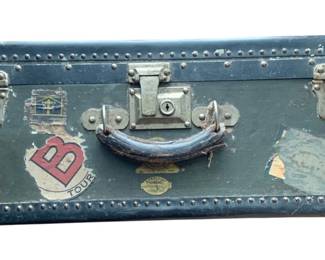 1414 - Vintage Suitcase Trunk 9.5"x26.5"x15" (Description): Vintage suitcase trunk adorned with travel  stickers and labels from various destinations  and cruise lines. Features metal corner  protectors and side latches.