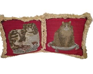 3775 - Pr Red Tapestry Pillows w/ Cat & Dog Motifs (Description): A pair of decorative tapestry pillows  featuring charming animal motifs. One pillow  depicts a Cavalier King Charles Spaniel,  while the other shows a long-haired cat. Both  designs are woven in muted earth tones against a rich red background. Each pillow is  finished with cream-colored fringe trim  around the edges.