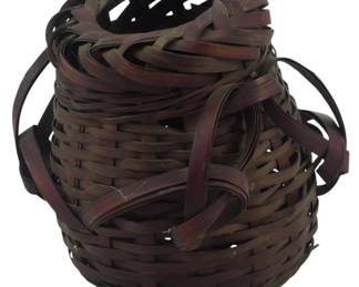 857 - Vintage Japanese Ikebana Basket 4.5" (Description): Vintage Japanese Ikebana basket featuring  traditional woven splint construction. The  basket has a round bulbous body with a  decorative loosely woven top section creating  an artistic sculptural effect typical of ikebana flower arranging vessels. Twoside  handles are incorporated into the weave. The  basket displays a warm brown patina  throughout. Measures 4.5 inches.