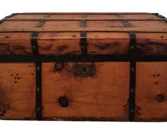 3708 - Wooden Dome Top Trunk 14"x30"x16" (Description): Antique wooden dome top trunk featuring metal  strap banding and decorative brass hardware.  The trunk displays a warm honey-toned wood  finish with iron corner brackets and riveted  accents throughout. An ornate brass lock plate adorns the front center. Measures 14  inches high by 30 inches wide by 16 inches  deep.