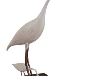 439 - Carved Wooden Crane & Baby Bird Statue (Description): Carved wooden crane and baby bird statue  featuring a graceful white-painted crane with  elongated neck and black beak, standing  alongside a small chick. Both birds are  mounted on a dark wooden base. The piece has been repaired. Measures 41" x 31".