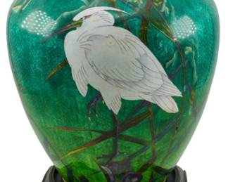 188 - Cloisonne Enamel Meiji Period Vase w/ Stand (Description): A cloisonne enamel vase from the Meiji  period, featuring intricate enamelwork  depicting a white egret among reeds and  foliage against a vibrant green ground. The  vase is presented on a carved wooden stand. Measures 11 inches.