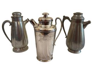 570 - 3 Cocktail Shakers Pewter & SP 10.5" (Description): Collection of three vintage cocktail shakers  in pewter and silver plate. The group  includes one shaker with an etched scenic  design depicting figures in a social setting,  along with two pewter shakers with classic streamlined silhouettes. Tallest measures  10.5 inches.