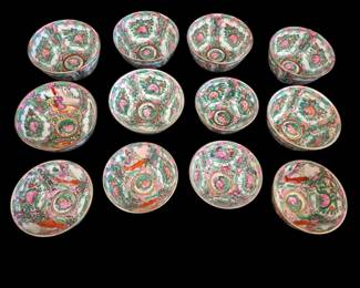 497 - 12 Rose Medallion Bowls 4.5" & 4" (Description): Collection of Chinese Rose Medallion  porcelain bowls in two sizes. The set  includes nine bowls measuring 4.5 inches in  diameter by 2 inches tall, and five bowls  measuring 4 inches in diameter by 2 inches tall. Each bowl features the traditional Rose  Medallion pattern with hand-painted panels  depicting figures, birds, butterflies, and  floral motifs in characteristic pink, green,  and gold enamels on a white ground. The