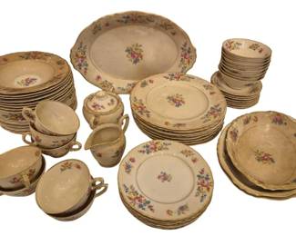 2752 - 62 Pcs Federal Syracuse China Floral Pattern (Description): A 62-piece set of Federal Syracuse china  featuring a delicate floral pattern with  roses and mixed blooms. The set includes  dinner plates, salad plates, bread plates,  soup bowls, fruit bowls, teacups with saucers, a covered sugar bowl, creamer, and  an oval serving platter. The pieces display a  cream-colored background with gold trim  along the scalloped edges. The set needs  cleaning.