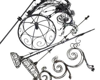 4130 - Metal Wire Christmas Tree with Scroll Design (Description): Metal Christmas tree featuring ornate  scrollwork construction. The tree appears to  be crafted from dark metal wire formed into  decorative spiral and scroll patterns. The  design includes a circular top section with radiating scroll motifs and an elongated  conical body section with elaborate curling  wire details. Designed to be assembled with  included metal support poles.