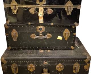 4095 - 3 Vtg Trunks w/ Brass Hardware Full of Fabric (Description): Collection of three vintage trunks featuring  brass hardware and corner protectors. The  trunks display classic steamer trunk styling  with metal latches, handles, and decorative  brass accents. Each trunk shows age-appropriate patina and wear consistent  with their vintage character. The collection  includes varying sizes suitable for storage  or decorative display.