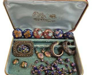 2701 - Cloisonne Jewelry Collection in Asian Box (Description): A collection of cloisonne jewelry presented  in a decorative Asian-style box with red  exterior and silk-lined interior featuring a  pagoda design. The collection includes  assorted cloisonne beads with floral motifs in cobalt blue and red tones, a pair of  cloisonne bangle bracelets with intricate  enamel work, a rectangular millefiori-style  brooch, a beaded necklace with blue and pink  cloisonne beads, floral earrings, and a small