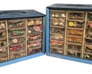 4111 - Two Vintage Storage Boxes Filled w/ Buttons (Description): Two vintage multi-drawer storage boxes filled  with an extensive collection of buttons. The  metal organizer boxes feature clear plastic  pull-out drawers, allowing visibility of the  varied contents. The button collection includes a wide assortment of styles, sizes,  colors, and materials, ranging from  utilitarian to decorative examples. An  excellent lot for crafters, sewers, or  collectors.