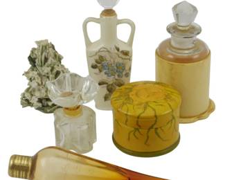 889 - Assorted Vtg Perfume Bottles & Vanity Items (Description): Assorted vintage vanity items including a  hand-painted porcelain double-handled perfume  bottle with floral decoration and white  stopper, a clear glass perfume bottle with  decorative stopper, an amber glass teardrop-shaped perfume bottle with brass  cap, a yellow painted glass cologne bottle  with faceted crystal stopper on pedestal  base, a yellow floral decorated round lidded  box, and a bisque porcelain floral bouquet