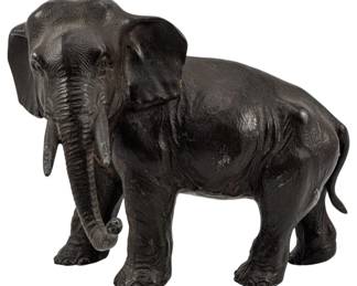 719 - Vintage Metal Elephant 6.5"x8"x5" (Description): Vintage metal elephant figure measuring 6 1/2  inches by 8 inches by 5 inches. This  decorative sculpture depicts a standing  elephant with detailed features including  textured skin, tusks, and a curled trunk.