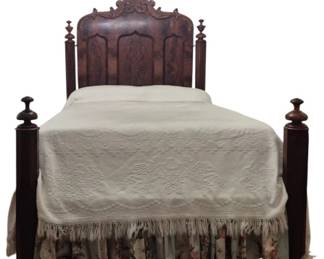 1259 - Victorian Swinging Headboard Bed w/ Bedding (Description): Antique Victorian carved four post bed  featuring an ornate headboard with elaborate  carved crest and flame mahogany veneer panels  in Gothic arch design. The bed has tall  turned posts with urn-shaped finials on all four corners. The rich dark mahogany wood  displays beautiful figured grain throughout  the headboard panels. Measures 80" x 64" x  93" overall. Vintage bedspread, mattress,  bedding, and bed skirt are included.