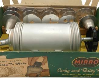 1234 - Vtg Mirro Aluminum Cooky & Pastry Press (Description): Vintage midcentury Mirro aluminum cooky and  pastry press in original yellow box. The box  features colorful illustrations of various  cookies and pastries that can be made with  the press, including cream puffs, meringue shells, eclairs, lady fingers, and fancy  cookies. Used as is electric/electronic/mechanical  item. No guarantee all components, untested.