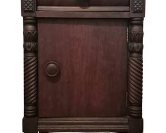 3701 - Vtg Carved Mahogany Nightstand 27"x17"x14" (Description): Vintage carved mahogany nightstand featuring  a single drawer with round wooden knob pull  above a single door cabinet. The piece  showcases decorative carved rope twist  columns flanking the cabinet door, lattice carved corner details, and turned bunn feet.  Dark rich finish throughout. Measures 27  inches high by 17 inches wide by 14 inches  deep.