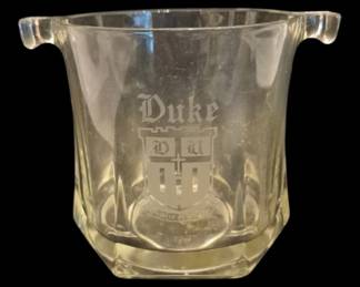2749 - Crystal Duke University Ice Bucket 6"x7" (Description): Crystal ice bucket featuring an etched Duke  University crest and name. The bucket has a  faceted design with decorative handles on  each side for easy carrying. Measures 6  inches by 7 inches.