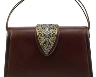 1781 - Vintage Leather Handbag 8"x12"x4" (Description): Vintage leather handbag featuring an ornate  decorative metal clasp closure and a curved  metal handle. The bag measures 8 inches high  by 12 inches wide by 4 inches deep.