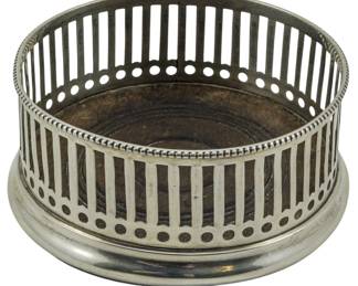 72 - Dominick & Haff Sterling Bottle Coaster (Description): A sterling silver bottle coaster by Dominick  & Haff. This piece features a pierced gallery  design with vertical slats and circular  perforations. The sterling silver weight is  2.22 ounces. Measurement of 2"x4.5".