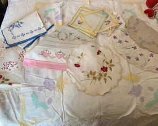 1375 - Lot of Embroidered Linens (Description): A lot of embroidered linens featuring various  decorative pieces including tablecloths,  doilies, and napkins with floral and  geometric embroidery patterns in assorted  colors.