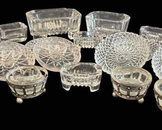 484 - Glass Salt Dips & Butter Pats (Description): A collection of glass salt dips and butter  pats. The assortment includes various pressed  glass patterns and styles, featuring both  open salt cellars and flat butter pat dishes.