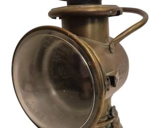 2750 - Antique Dietz Brass Automobile Lantern (Description): Antique Dietz brass automobile lantern  featuring a cylindrical body with a large  glass lens door that swings open, a curved  carrying handle, and a stepped chimney top.  The lantern displays the characteristic patina of aged brass throughout. Measures10  inches by 6 inches by 6 inches. Used as is electric/electronic/mechanical  item. No guarantee all components, untested.