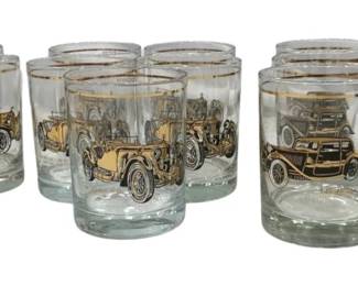 1226 - Vtg Automotive Themed 4.5" Glasses, Gold Trim (Description): Set of four vintage automotive themed glasses  featuring gold trim at the rim. Each glass  is decorated with illustrations of antique  automobiles in gold and earth tones,  depicting classic cars from the early automotive era. The clear glass tumblers make  an excellent addition to any barware  collection or for the automobile enthusiast.