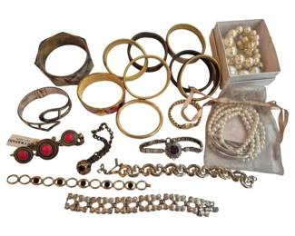 1992 - Group of Assorted Costume Jewelry Bracelets (Description): A collection of assorted costume jewelry  bracelets featuring a variety of styles  including gold-tone bangles, chain link  bracelets, cuff bracelets, and beaded pearl  designs. The group includes both statement pieces with decorative stones and simpler  everyday styles in various metallic finishes.