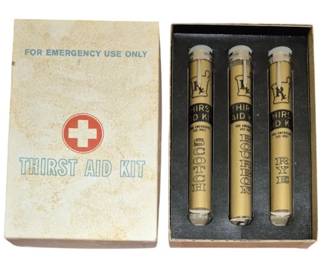 4050 - Vtg Thirst Aid Kit Novelty Bar Box (Description): Vintage novelty "Thirst Aid Kit" box designed  to resemble a first aid kit. The box  features a red circle with a white cross  emblem and reads "For Emergency Use Only" at  the top. Includes Scotch, Burboun & Rye Vials. A humorous barware or gag gift item  with an aged, weathered appearance.