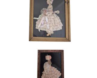 1299 - Pr Vtg Framed Ribbon Paper Doll Art 27"x28" (Description): A pair of vintage framed ribbon and paper  doll artworks depicting ladies in elaborate  Victorian-style ruffled dresses. The larger  piece features a woman in a cream-colored  tiered gown holding a bouquet of flowers, set against a dark background in agilt wood  frame. The smaller piece shows a similar  figure in a pink and white lace dress within  a carved dark wood frame. The larger frame  measures 11.5" x 9.5".