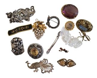 445 - Group Sterling & Etc Vintage Brooches & Pins (Description): Variety of styles and periods. The collection  includes an Art Nouveau style figural  brooch, a marcasite peacock pin, a faux pearl  grape cluster brooch, Victorian-style  mourning jewelry pieces with photo compartments, a rhinestone circle pin, an  amethyst-colored glass brooch, a  damascene-style bar pin, and additional  decorative pieces. An eclectic assortment  suitable for collectors of vintage costume
