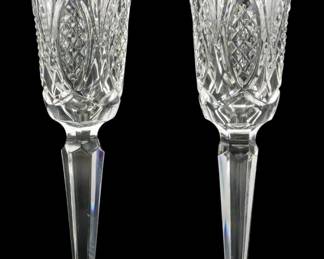 135 - Pr Waterford Glass Champagne Flutes 9" (Description): A pair of Waterford glass stems measuring 9  inches in height. These elegant crystal  pieces feature the distinctive cut patterns  characteristic of Waterford craftsmanship.