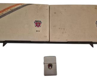 3799 - Ford Presentation Watch Box & Lighter (Description): Vintage Ford presentation set featuring a  hinged "His" and "Hers" watch box with  matching Zippo-style lighter. The  cream-colored leatherette box displays  "Championship Sales Manager" text with orange and gray racing stripes across the top  corner.  Each side features the classic Ford  crest emblem in enamel. The accompanying  lighter also bears the Ford crest emblem.  Measures 1.5"x14"x4.5".