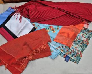 2855 - Assorted Doncaster Scarves Collection (Description): A collection of assorted Doncaster scarves  featuring a variety of colors and patterns.  The grouping includes a red textured  chevron-patterned wrap with fringe, an orange  woven scarf with fringed ends, a color-block silk scarf in blue, red, white and black  reminiscent of Mondrian designs, a light blue  floral print scarf with orange accents, and  a tropical floral print scarf in greens and  oranges. Various sizes and fabric weights