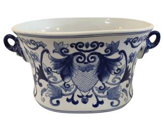 411 - Blue & White Ceramic Cachepot Planter (Description): Blue and white ceramic cachepot or tub  planter featuring hand-painted decorative  motifs in a Delft-style design. The piece  showcases an ornate central cartouche with  scrolling floral and foliate patterns, accented by loop handles on either side.  Measures 6.5" x 11".