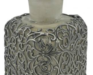 871 - Vtg Persian Perfume Bottle Silver Overlay (Description): Vintage Persian perfume bottle featuring a  potential silver overlay with intricate  scrollwork design. The bottle is topped with  a faceted crystal stopper. Measures 7 inches  tall.