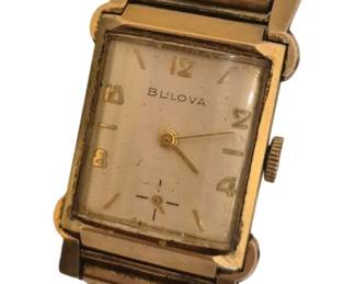 1488 - Vtg Bulova Gold-Tone Rectangular Wristwatch (Description): Vintage Bulova wristwatch featuring a  rectangular gold-tone case with a  cream-colored dial. The watch displays Arabic  numerals at the 12, 2, 4, 6, 8, and 10  positions, with gold-tone hands and the Bulova name printed on the dial. The  timepiece is fitted with an expansion  bracelet in a matching gold-tone finish. The  watch shows signs of age consistent with  vintage use.