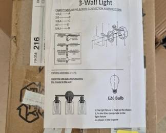2836 - 3-Light Wall Fixture in Original Box (Description): A 3-light wall fixture, new in original box.  The fixture uses E26 bulbs and includes  assembly and installation instructions. The  packaging shows diagrams indicating a  traditional style wall-mounted light with multiple glass shades. Used as is electric/electronic/mechanical  item. No guarantee all components, untested.