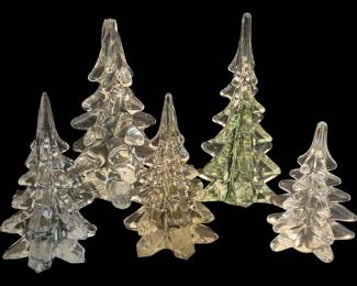 2790 - 5 Clear Art Glass Christmas Tree Figurines 8" (Description): Collection of five art glass Christmas tree  figurines in varying sizes. The set includes  clear and pale green tinted examples, each  featuring a tiered design with flowing  branch-like tiers rising to a pointed top on a star-shaped base. Largest measures 8 inches  tall.