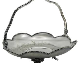 94 - James W. Tufts Quadruple Plate Basket 9"x10" (Description): A James W. Tufts quadruple plate basket  featuring elegant beaded detailing along the  scalloped rim and swing handle. The basket  rests on decorative scroll feet. Measures 9  inches by 10 inches.