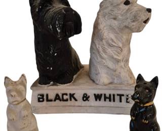 3941 - Black & White Whisky Figurines & Shakerss (Description): Black & White Whisky figurines and salt and  pepper shakers featuring Scottish Terrier  dogs. The set includes a larger advertising  display piece with a black Scottie and white  West Highland Terrier seated together on a base marked "BLACK & WHITE," accompanied by a  pair of smaller Scottie dog shakers in  coordinating black and white. The pieces  appear to be painted ceramic or chalkware,  showing characteristic vintage charm with