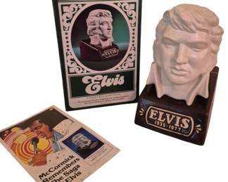 3983 - McCormick Elvis Presley Decanter w/ Box (Description): McCormick Elvis Presley commemorative liquor  decanter, no contents included. The ceramic  decanter features a bust of Elvis in white on  a dark brown pedestal base marked "Elvis  1935-1977." Comes with original box featuring decorative scrollwork design and "Elvis  Limited Edition" text. Also includes  "McCormick Remembers The Saga of Elvis"  booklet.