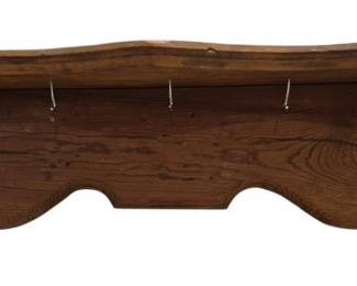 3955 - Rustic Carved Wood Wall Shelf with Hooks (Description): A rustic wooden wall shelf featuring  decorative carved corbel brackets on each  side and a shaped apron with arched cutouts.  The shelf includes four metal hooks mounted  underneath for hanging items. The piece displays warm wood tones with visible grain  patterns, suggesting solid hardwood  construction in a country or farmhouse style.