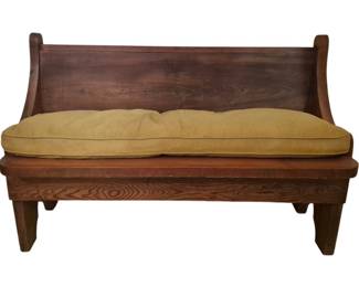 3773 - Rustic Pine Bench w/ Cushion 32.5"x50"x20" (Description): A rustic pine bench with cushion, featuring a  solid plank seat and back with curved  scrolled arms on each side. The bench has a  warm, natural wood finish that showcases the  grain pattern and knots characteristic of pine. It rests on sturdy tapered legs.