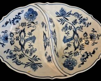 515 - Blue Danube Divided Serving Bowl 11"x7.5" (Description): A classic Blue Onion pattern divided serving  bowl featuring the traditional Zwiebelmuster  design with hand-painted floral and botanical  motifs in cobalt blue on white porcelain.  The oval dish is divided into two equal sections, each displaying the iconic stylized  peony, chrysanthemum, and bamboo elements  characteristic of this 18th-century  Meissen-inspired pattern. The scalloped edge  is accented with a delicate blue line.