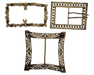 1485 - Three Antique Gilt Metal Belt Buckles (Description): Collection of three antique gilt metal belt  buckles. The group includes one rectangular  buckle with ornate floral cluster decorations  around the border, one rectangular openwork  buckle with geometric lattice pattern and prong closure, and one Art Nouveau style  square buckle featuring curved openwork wings  design with turquoise colored cabochon  accents. All display aged patina consistent  with their vintage origin.