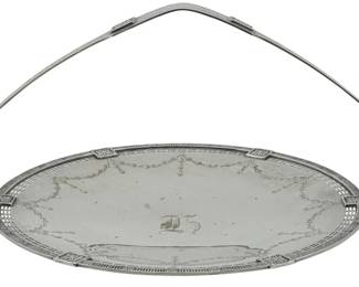 112 - Silver Plate Compote Wallingford by Wallace (Description): Silver plate compote in the Wallingford  pattern by Wallace. This elegant oval piece  features a graceful swing handle and  decorative pierced gallery edge. The surface  displays engraved garland and swag designs with a central monogram. Measures 7 inches