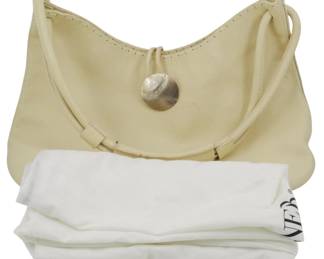 1814 - Tanner Leather Tote Bag w/ Storage Bag (Description): Tanner leather tote bag in a cream color,  featuring a mother of pearl button closure  and single shoulder strap. Includes original  storage bag for protection. Measures 13  inches by 15 inches.