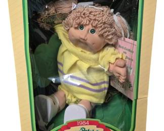 4157 - CPK Katrina Emelita (Description): Cabbage Patch Kids doll named Katrina  Emelita. The doll is presented in its  original 1984 packaging and includes birth  certificate and adoption papers.