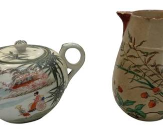 987 - Asian Ceramic Teapot & Pitcher Set (Description): Asian ceramic tea set featuring a white  teapot with hand-painted figural and bamboo  decoration, accompanied by a cream-colored  pitcher with burgundy handle and spout,  decorated with painted floral and berry motifs. Both pieces display traditional Asian  artistic styling with delicate brushwork  details.