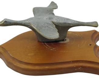 1882 - Vintage Flying Goose Hood Ornament 4"x10"x7" (Description): Vintage flying goose hood ornament mounted on  a shaped wooden base. The ornament depicts a  goose in flight with outstretched wings and  extended neck. Measures 4 inches high by 10  inches wide by 7 inches deep.